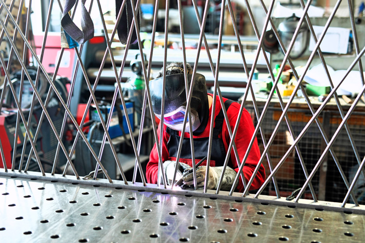 Ein Stiegeler-Metallbau-Mitarbeiter verschweißt eine Gitterblende