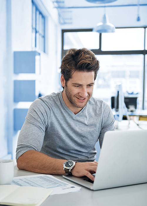 Fröhlicher Student an seinem Laptop